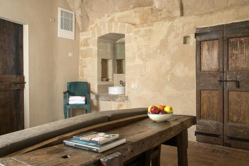 a room with a table with a bowl of fruit on it at Locanda Di San Martino Hotel & Thermae Romanae in Matera