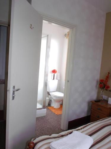 a bedroom with a bathroom with a toilet and a window at Jasmine Guest House in Bridlington