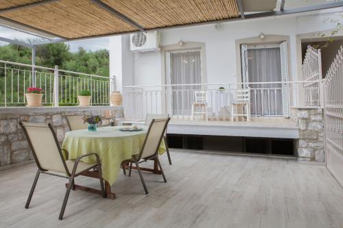 a patio with a table and chairs and a bench at Remezzo Apartments in Akrogiali