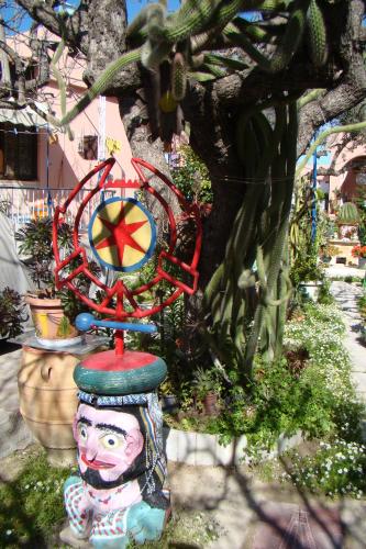 a statue of a clown with a clock on top at Kalokenti Studios in Aegina Town