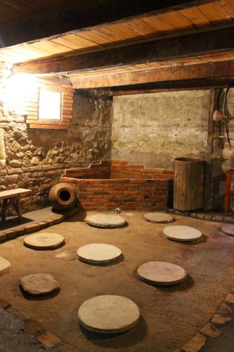 a room with a brick wall and a room with circular tables at GreenGate in Gurjaani