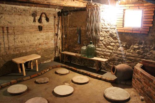 a room with a group of wooden stools and a table at GreenGate in Gurjaani
