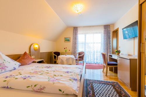 ゲルンスバッハにあるGästehaus Sonneのベッド、テーブル、椅子が備わるホテルルームです。