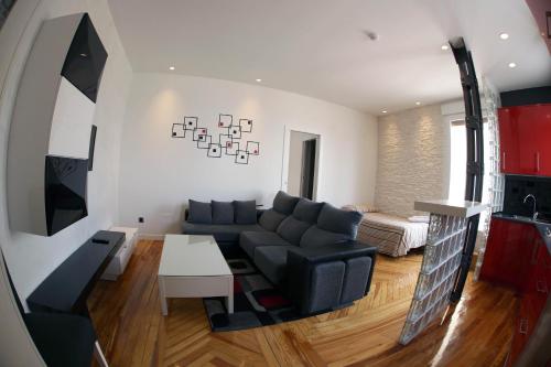 sala de estar con sofá y mesa en Apartamentos Apolo, en Madrid