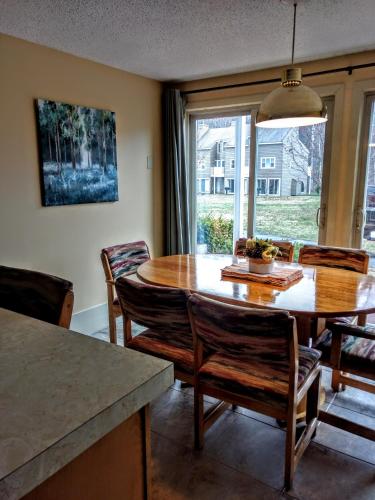 a kitchen and dining room with a wooden table and chairs at Cathedral Ledge Resort in North Conway