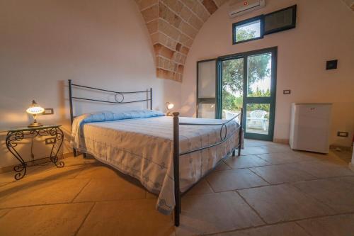 ガラティーナにあるMasseria Fracchicchiのベッドルーム1室(ベッド1台、ランプ付きテーブル付)