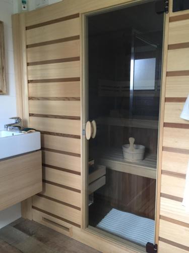 a kitchen with a glass cabinet with a sink at Le Gîte "Le Grand Chêne" in Le Cloître-Saint-Thégonnec