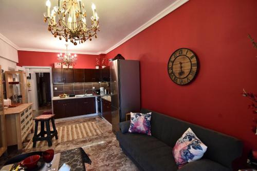a living room with a couch and a clock on a wall at Queens Bed&Rest Luxury Apartment in Kavala