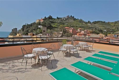 eine Gruppe von Tischen und Stühlen auf einem Dach in der Unterkunft Hotel La Colonnina in Monterosso al Mare