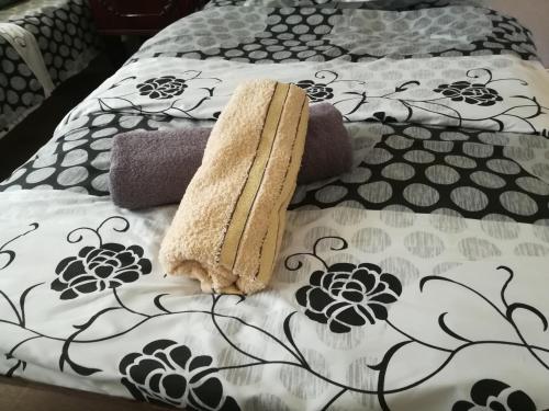 a bed with a comforter and pillows on it at Tbilisi guesthouse Nini in Tbilisi City