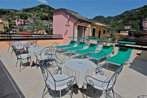 a row of tables with chairs and umbrellas at Hotel La Colonnina in Monterosso al Mare