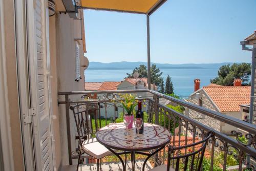 a table on a balcony with a view of the ocean at Apartment Ariana in Bol