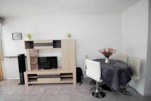sala de estar con mesa y TV en HACIENDA- Grand studio dans le centre avec vue mer en Canet-en-Roussillon