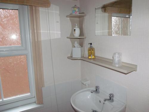 a white bathroom with a sink and a mirror at Jasmine Guest House in Bridlington