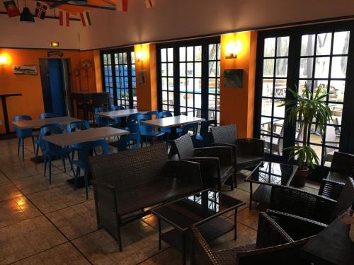 un restaurant avec des tables, des chaises et des fenêtres dans l'établissement La Sensation, à Matringhem