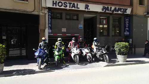 un grupo de personas en motocicletas estacionado frente a un edificio en Hostal Palafox en Barbastro