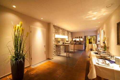 a living room with a table and a kitchen at Hotel Backenköhler in Ganderkesee