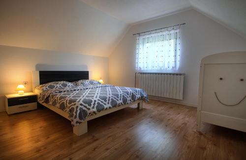 a bedroom with a bed with a comforter and a window at Apartment Lana in Rakovica