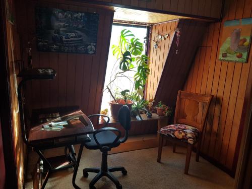 um quarto com uma secretária, uma cadeira e uma janela em La Casa Guesthouse em Punta Arenas
