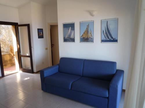 a blue couch in a living room with pictures on the wall at Casa Magda in Costa Paradiso