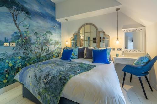 a bedroom with a large bed with blue pillows at No33 THORNHAM BOUTIQUE COTTAGE 2 in Thornham
