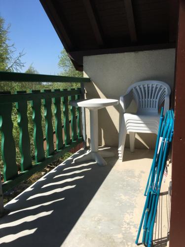 a white table and a chair on a balcony at Duplex Métabief in Métabief