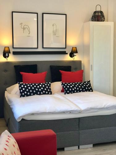 a bed with red and black pillows in a room at DAS Apartment am Weinberg in Geisenheim