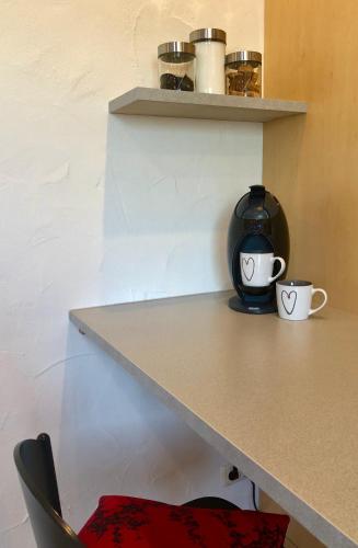 a table with two coffee cups on a shelf at DAS Apartment am Weinberg in Geisenheim