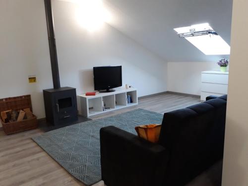 a living room with a couch and a flat screen tv at O Sótão do Mé-Mé in Manteigas