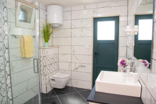 a bathroom with a white toilet and a sink at Villa Lucija Bol in Bol