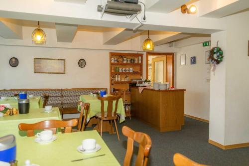 a dining room with tables and chairs and a kitchen at Pension zum Schwanenteich in Neuhaldensleben