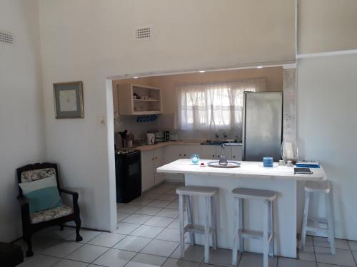 a kitchen with a white island in a room at Milkwood Beach Cottages in Shelly Beach