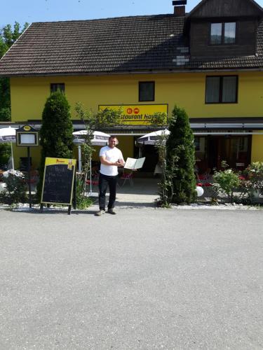 a man standing in front of a yellow building at Ferienhaus Silja in Steindorf am Ossiacher See