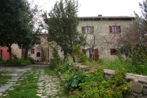 una antigua casa de piedra con un jardín delante de ella en Sa Domu de sa Contissa, en Sèlegas