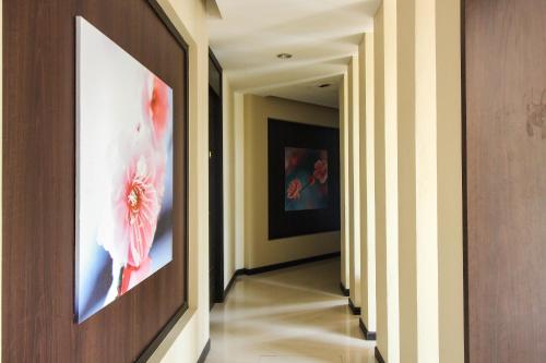 a hallway with a painting of a flower on the wall at Jumbo House in Tha Sae