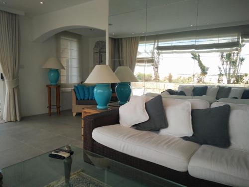 a living room with a white couch and blue chairs at St. Agatha's Bastion in Mdina
