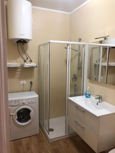 een badkamer met een wasmachine en een wastafel bij Lugana 17 in Sirmione