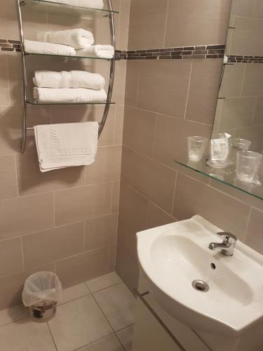bagno con lavandino, specchio e asciugamani di Abri Du Ventoux a Malaucène