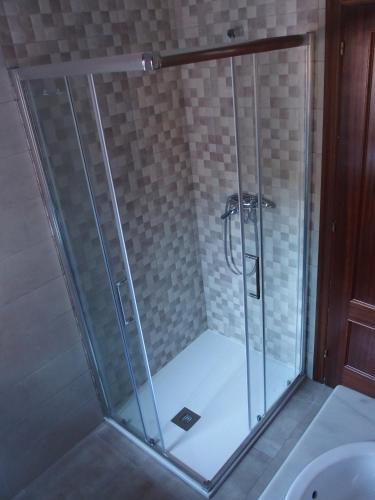 a shower with a glass door in a bathroom at Casa Grande de Borizu Playa in Celorio