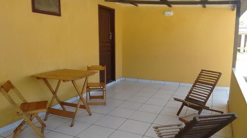 Habitación con sillas, mesa y mesa. en Casa na Praia Monte Alto - Arraial, en Arraial do Cabo