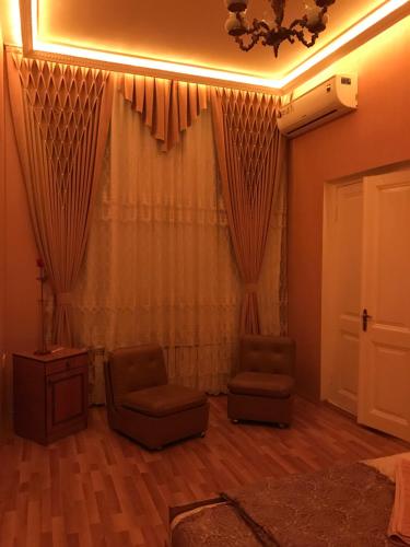 a living room with two chairs and a window at Beaming_House in Sheki