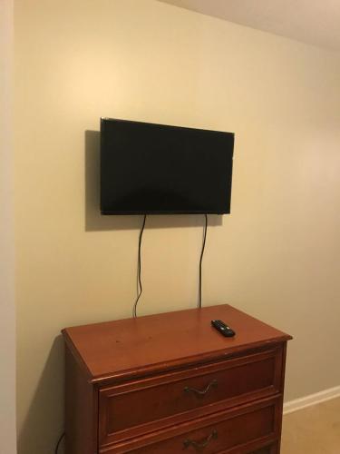 a flat screen tv sitting on top of a dresser at Red Carpet Inn, Alexandria in Alexandria