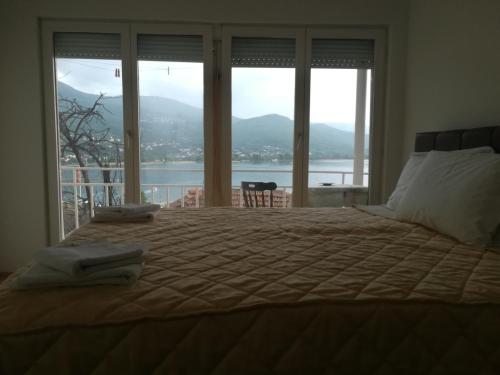 a bedroom with a large bed with a large window at Vila Mare in Ohrid