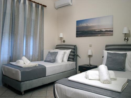 ハニア・タウンにあるUrban Sea Aptsのホテルルーム ベッド2台&椅子付