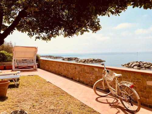a bike parked against a brick wall next to the ocean at La Terrazza nel Mare in Acciaroli