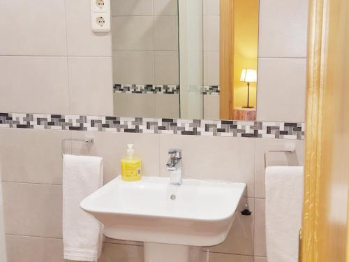 a white bathroom with a sink and a mirror at Hostal Puerta Bonita Vista Alegre in Madrid