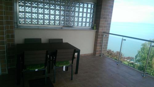a balcony with a table and chairs and a balcony with a view at Galerius Golden Beach Apartment in Siófok