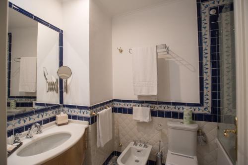 a bathroom with a sink and a toilet and a mirror at Hotel Posa Posa in Positano