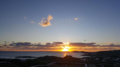 a sunset over the ocean with the sun in the sky at Empress Villa in Platis Yialos Mykonos