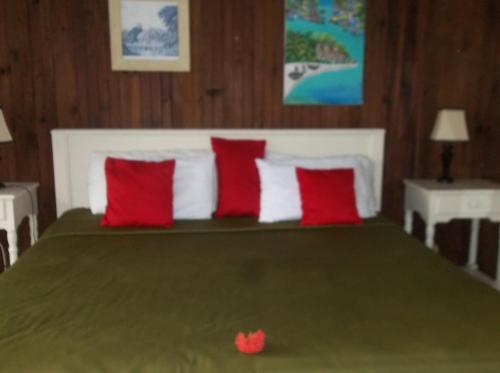 a bedroom with a large bed with red and white pillows at Fosters West Bay Resort in West Bay